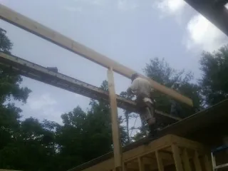 Carpenter setting a ridge beam over a new addition frame — Ice Dam Removal by Roofing Brothers in West Warren