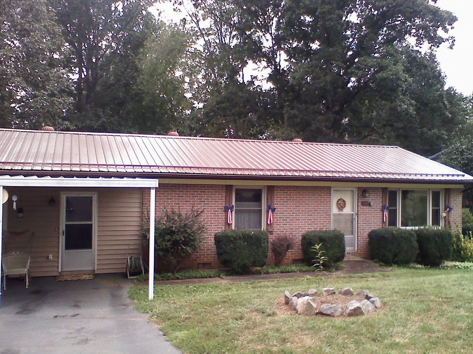 Bronze metal roof and carport on a brick ranch home — Roof Repair work by our crew in West Warren